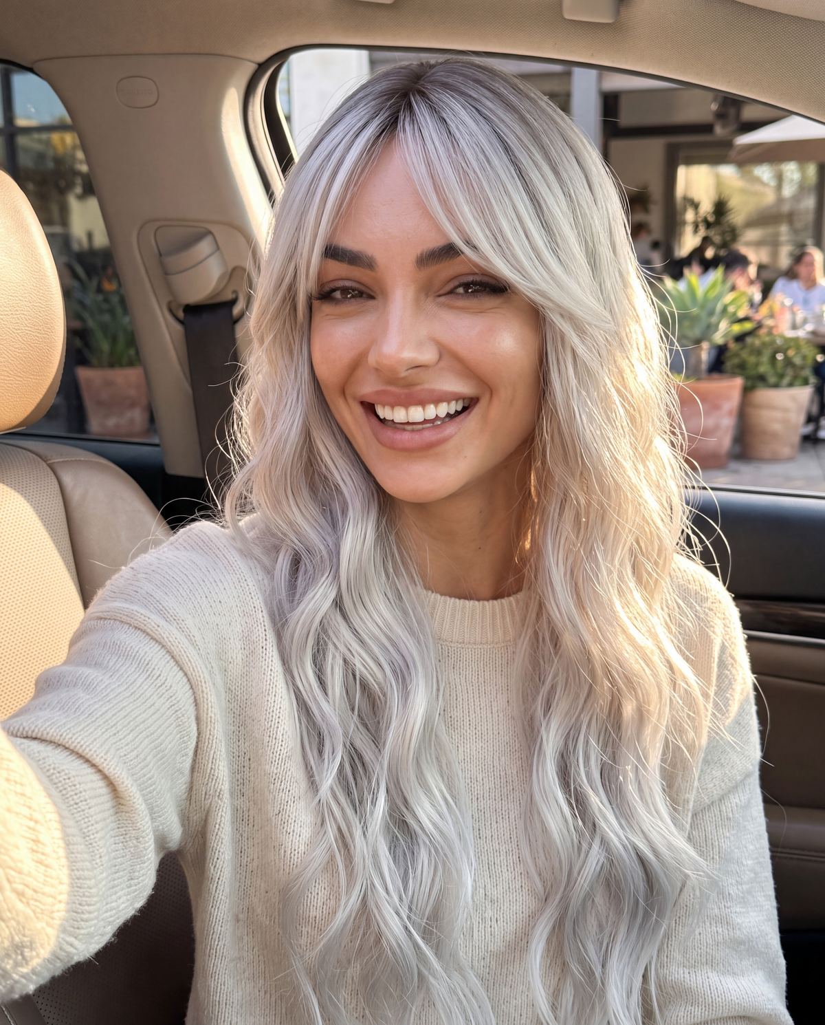 SILKORA 24 inch wavy full-head wig in Champagne Blonde, lifestyle car smile selfie on model